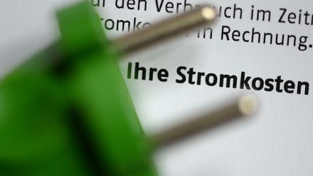 Ein Stromstecker liegt auf einer Stromrechnung.