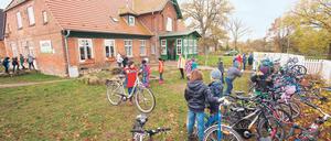 Kinder spielen vor einer privaten Grundschule in Mecklenburg-Vorpommern im Garten.