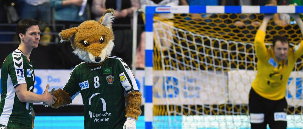 Hans Lindberg und Maskottchen Fuchsi stehen nach Spielende auf dem Feld.