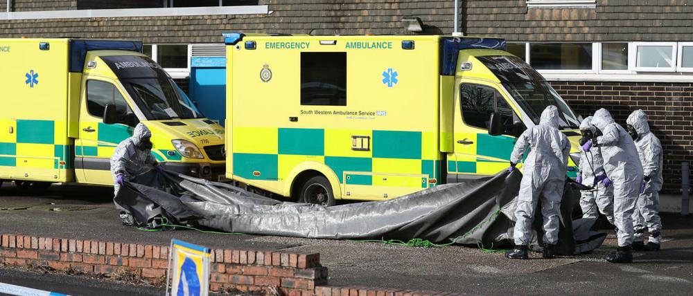Ermittler in Gasmasken untersuchen einen Krankenwagen auf Spuren von Nervengift.