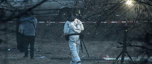Polizisten sichern Spuren am Fundort der Leiche. 