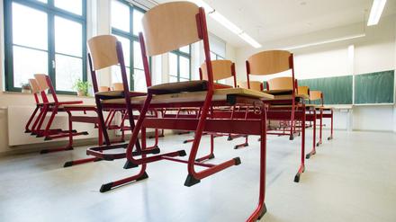 In einem leeren Klassenzimmer stehen Stühle auf den Tischen.