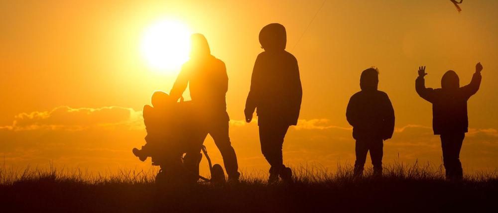 Eine Familie genießt den Sonnenuntergang an der Nordsee.