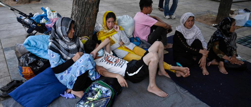 An Afghan family rests at Victoria square in central Athens, on July 29, 2020. - Around 100 mostly Afghan refugees have been camping in a square in recent days under temperatures exceeding 30 degrees Celsius (86 Fahrenheit) after arriving from island's camps. Refugees who were awarded asylum over a month ago, are allowed to leave Moria and other camps and sail to Athens, but without further assistance. "The camp authorities told us to leave Moria. But we were not told where to go, where to find assistance," a refugee says. (Photo by Louisa GOULIAMAKI / AFP)