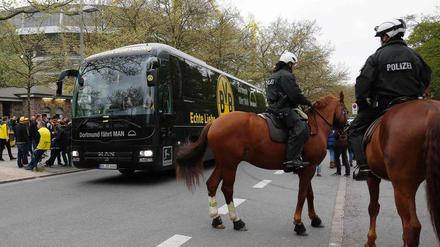 Ein Mannschaftsbus unter Polizeischutz.