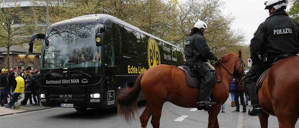 Ein Mannschaftsbus unter Polizeischutz.