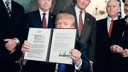 Trump zeigt das Dokument, mit dem er neue Strafzölle gegen China einführt.