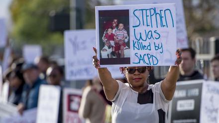 Eine Demonstrantin hält ein Schild mit einem Bild von Stephon Clark in die Höhe, der durch die Polizei erschossen wurde.