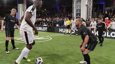 Usain Bolt will Ex-Weltmeister Carlos ausdribbeln, rechts schaut Maradona zu.
