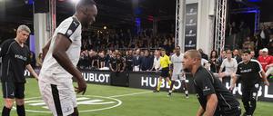 Usain Bolt will Ex-Weltmeister Carlos ausdribbeln, rechts schaut Maradona zu.