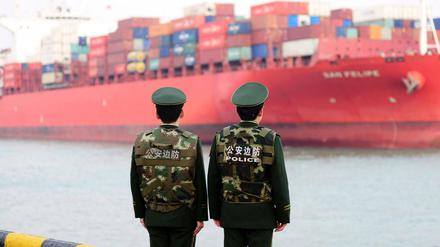 Qingdao: Polizisten beobachten die Ankunft eines Containerschiffs.