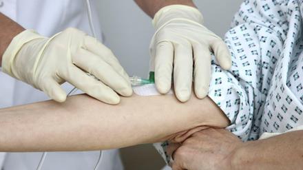 Eine Krankenschwester legt einen Zugang für eine Infusion.