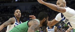 Hart umkämpft. Bostons Kyrie Irving (M) in Aktion gegen den verteidigenden Taj Gibson (r) aus Minnesota. 