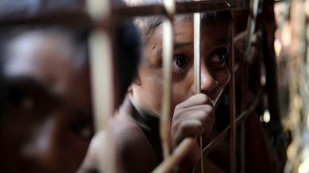 Ein junger Rohingya schaut durch ein Gitter in einem Flüchtlingscamp in Bangladesch.