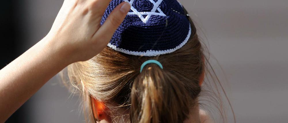 Eine junge Frau mit Kippa nimmt in Berlin an einer Demonstration teil.