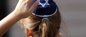 Eine junge Frau mit Kippa nimmt in Berlin an einer Demonstration teil.