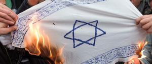 Jugendliche verbrennen in Neukölln nach einer Pro-Palästina-Demonstration eine selbst gebastelte Israel-Fahne.