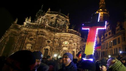 Wer das christliche Kreuz in den Nationalfarben anmalt, versteht die christliche Lehre nicht. Eine Pegida-Demonstration in Dresden. 