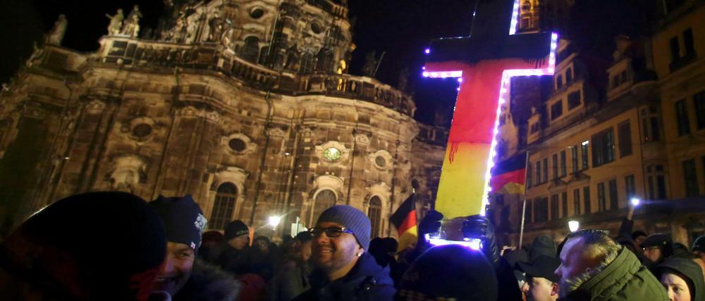 Wer das christliche Kreuz in den Nationalfarben anmalt, versteht die christliche Lehre nicht. Eine Pegida-Demonstration in Dresden.