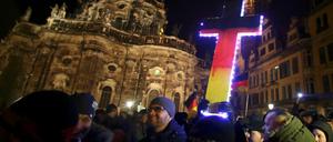 Wer das christliche Kreuz in den Nationalfarben anmalt, versteht die christliche Lehre nicht. Eine Pegida-Demonstration in Dresden. 