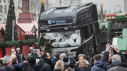Schaulustige und Reporter stehen vor dem LKW am Weihnachtsmarkt in Berlin. 