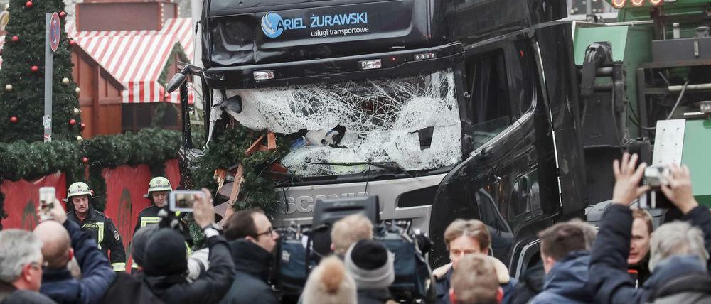 Schaulustige und Reporter stehen vor dem LKW am Weihnachtsmarkt in Berlin.