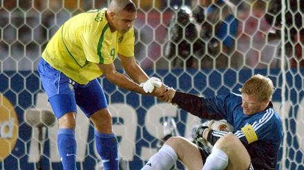 Tragik des Titan: Der brasilianische Stürmer Ronaldo (l) hilft Torhüter Oliver Kahn auf die Beine in Yokohama. 