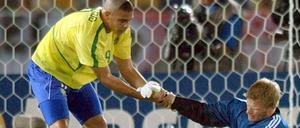 Tragik des Titan: Der brasilianische Stürmer Ronaldo (l) hilft Torhüter Oliver Kahn auf die Beine in Yokohama. 