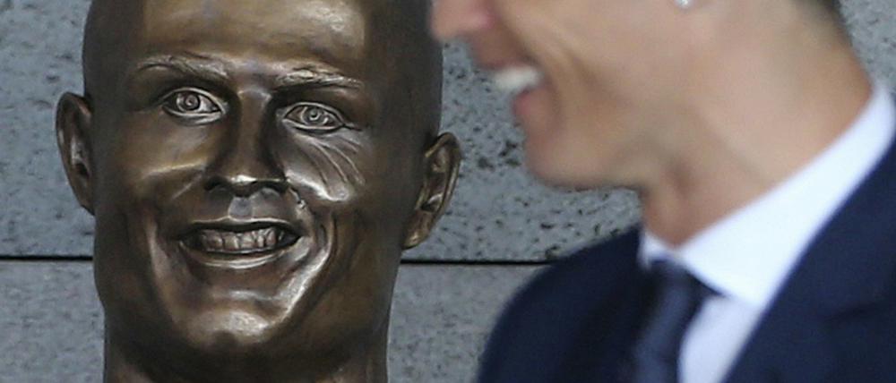 Cristiano Ronaldo in Funchal neben einer Büste, die ihn darstellen soll.