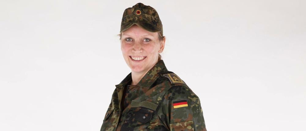 In einer gestellten Szene trägt eine Soldatin Umstandsmode.