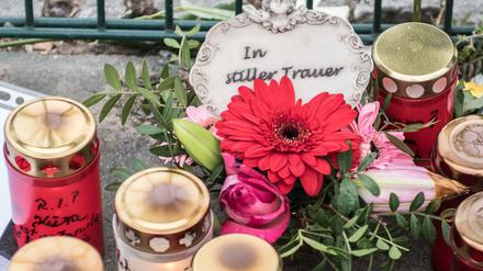 Blumen, Kerzen und Gedenkschreiben haben Menschen am Eingang zur Eisschnelllaufhalle abgelegt.