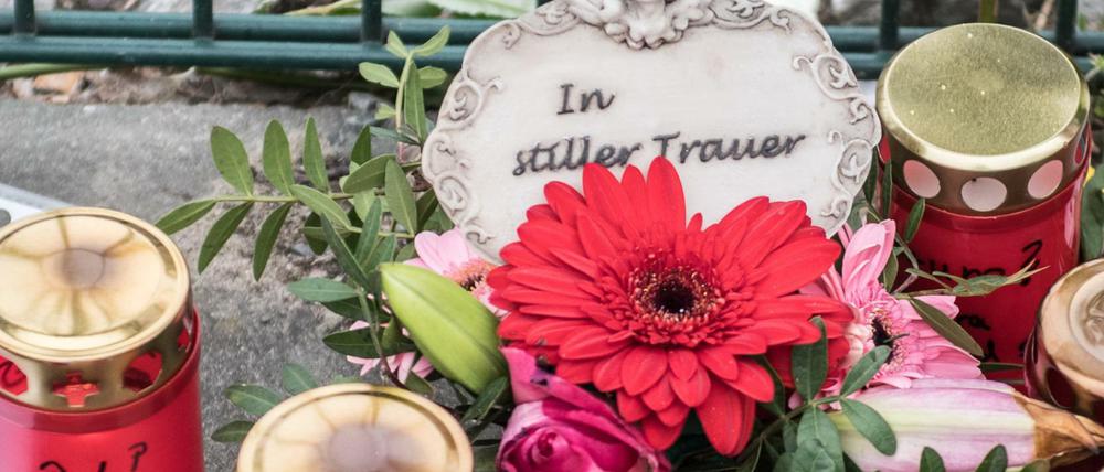 Blumen, Kerzen und Gedenkschreiben haben Menschen am Eingang zur Eisschnelllaufhalle abgelegt.