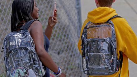 Zwei Schüler der Marjorie Stoneman Douglas High School tragen transparente Rucksäcke auf dem Rücken. 