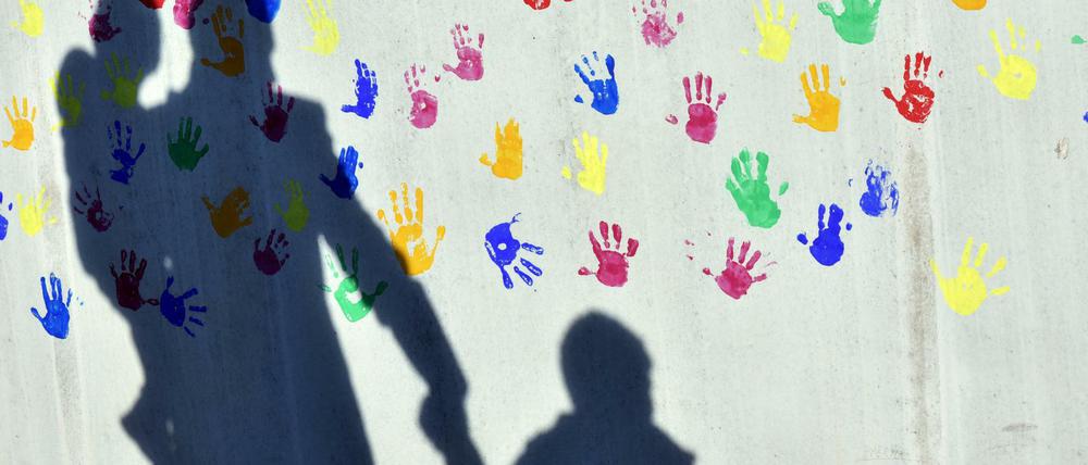 Ein Mann mit Kindern vor einer Kindertagesstätte