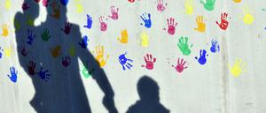 Ein Mann mit Kindern vor einer Kindertagesstätte