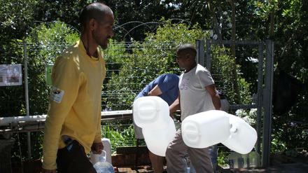 Einwohner füllen Wasserkanister an einer natürlichen Quelle in Kapstadts Vorort Newlands auf.
