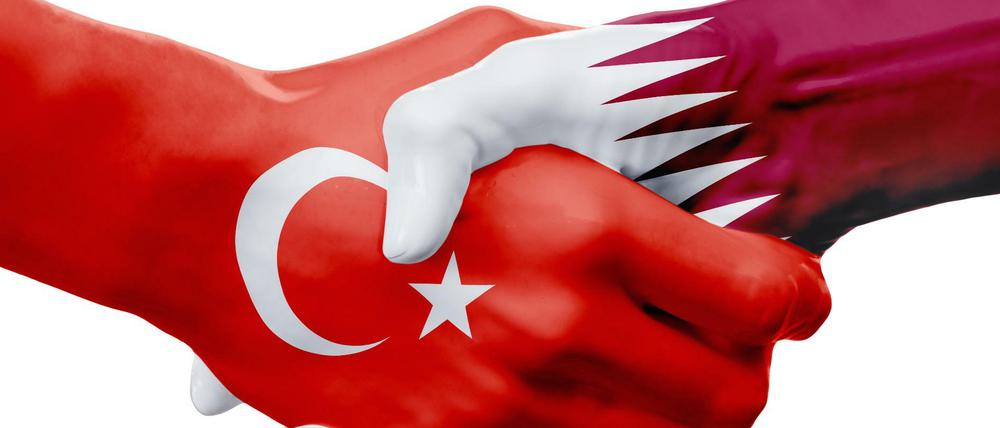 Eine Hand wäscht die andere, sagt ein Sprichwort. Diese beiden zeigen die Flaggen der Türkei und Katars.