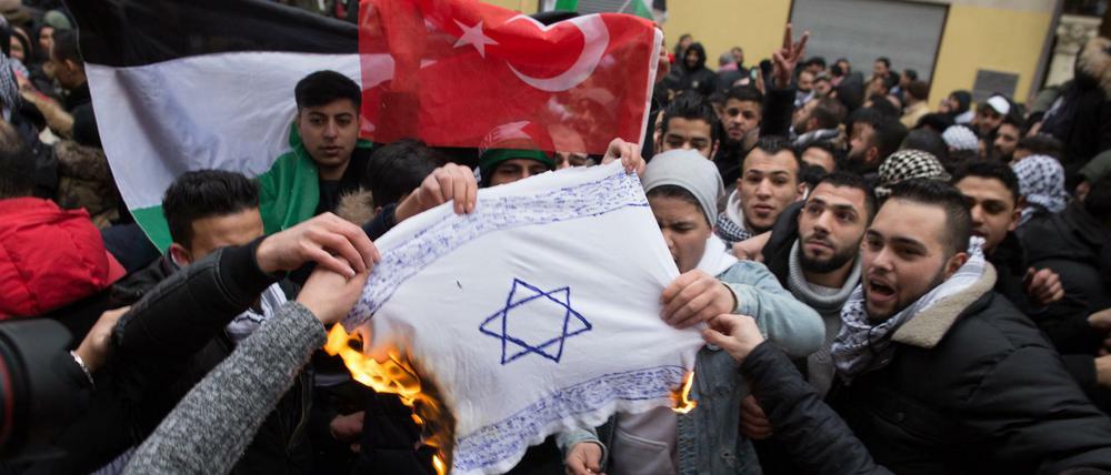 Bei Demonstrationen im Dezember 2017 in Berlin zündeten muslimische Antisemiten selbstgemalte Fahnen mit einem Davidstern an.