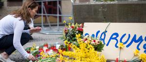 Eine Frau legt am Tatort in Münster Blumen nieder.