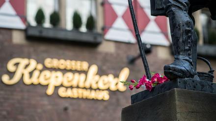 Eine Blume liegt am Tatort vor dem Kiepenkerl in Münster am Fuß der gleichnamige Figur. Ein Mann war am 07.04. mit einem Kleintransporter vor dem Restaurant in eine Gruppe von Menschen gerast und hatte zwei von ihnen getötet.