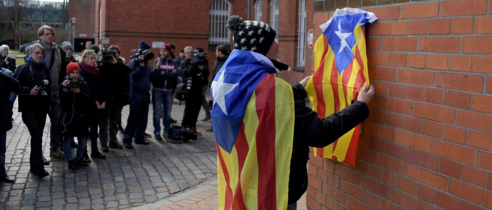 Eduard Alonso aus Girona in Katalonien hängt eine Estelada, die Fahne der katalanischen Nationalisten, an die Mauer der JVA Neumünster.