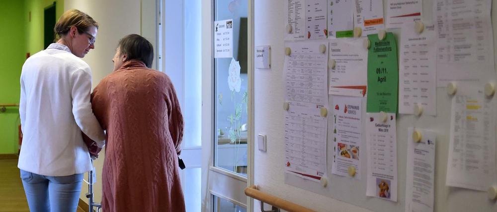 Die Bereichsleiterin einer Berliner Pflegeeinrichtung hilft einer Bewohnerin. 