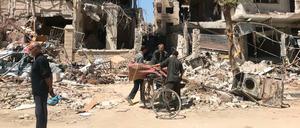 Menschen stehen vor den zerstörten Gebäuden in Duma, dem Ort in dem es angeblich einen Giftgasangriff gegeben haben soll. 