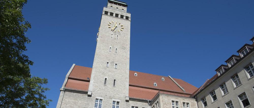 Blick von unten auf das Rathaus Neukölln unter blauem Himmel.