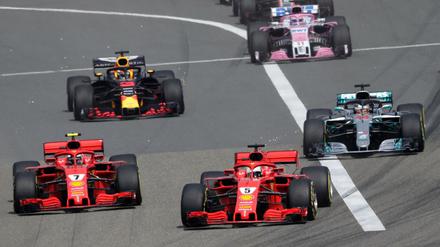 Sebastian Vettel (Mitte vorne) vom Team Scuderia Ferrari führt das Fahrerfeld nach dem Start an.