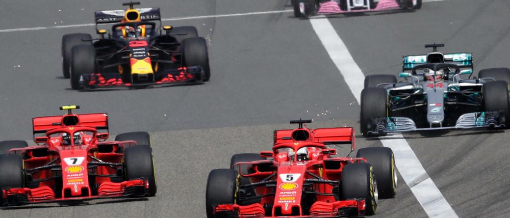 Sebastian Vettel (Mitte vorne) vom Team Scuderia Ferrari führt das Fahrerfeld nach dem Start an.