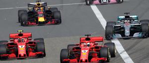 Sebastian Vettel (Mitte vorne) vom Team Scuderia Ferrari führt das Fahrerfeld nach dem Start an.