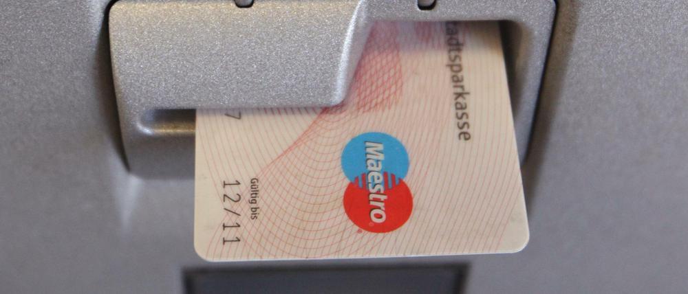 Eine EC-Karte steckt im Eingabeschlitz eines Geldautomaten.