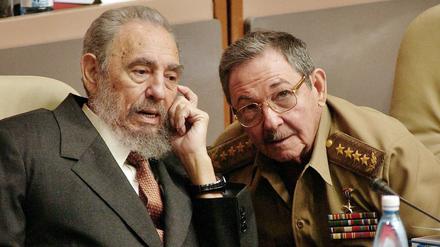 Der damalige kubanische Präsident Fidel Castro (l) spricht mit seinem Bruder Raul Castro (r). 