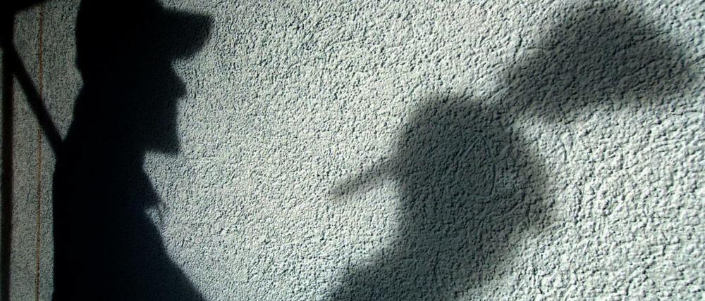 Der Schatten eines Malers ist auf einer Hauswand.